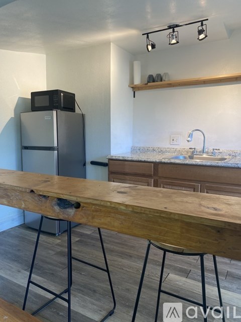 A kitchen with a wooden table and a refrigerator.