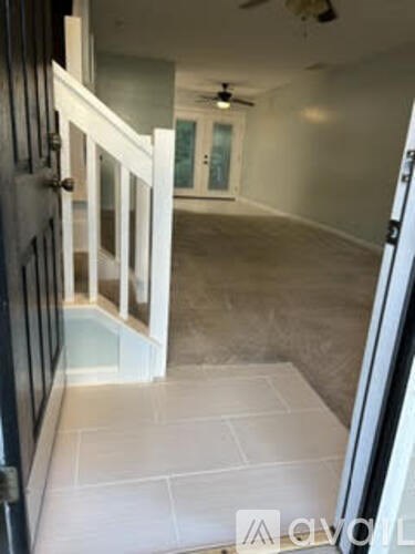 A hallway with a black door and a white door with a glass panel.