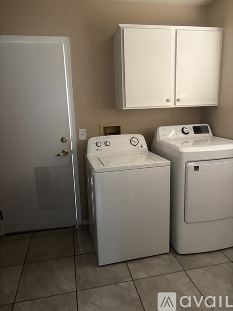 A white washing machine and dryer in a laundry room.