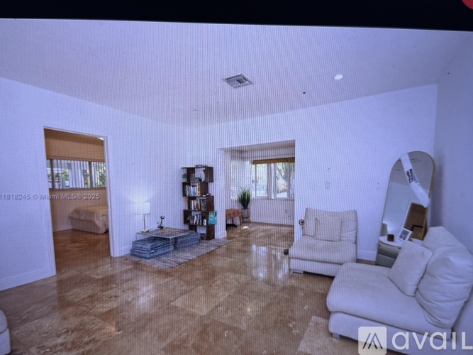 A living room with a white couch and a wooden floor.