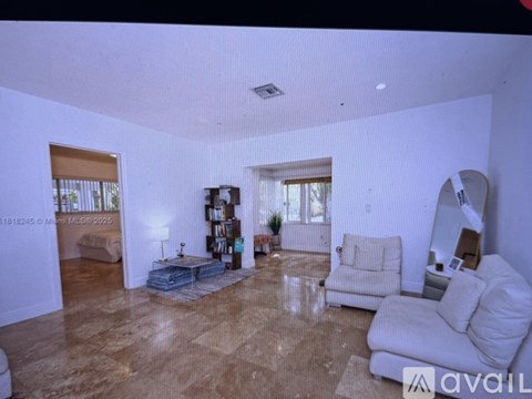 A living room with a white couch and a wooden floor.