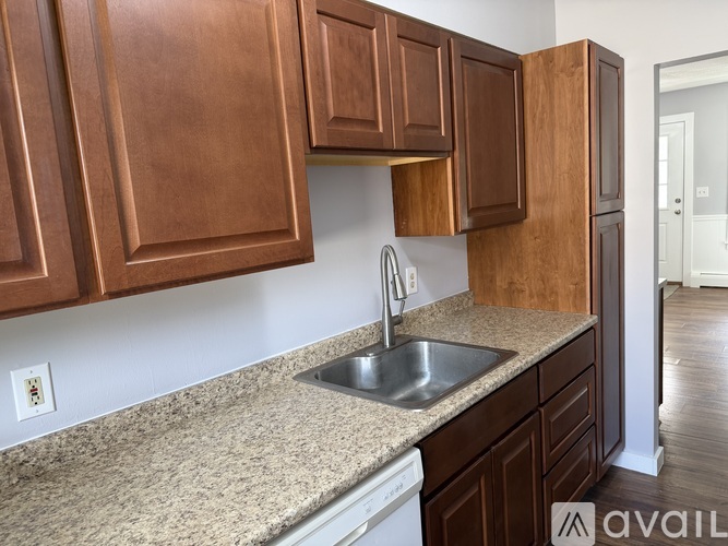 A kitchen with brown cabinets and a granite countertop.