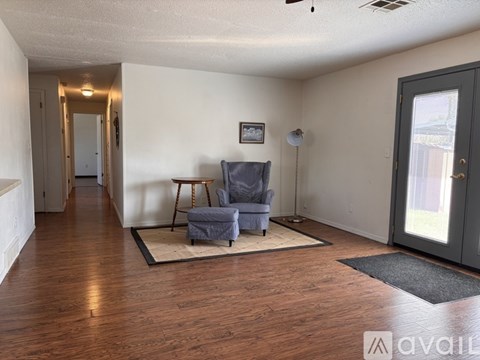 A living room with a grey couch and a wooden floor.