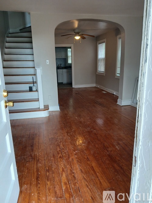 A room with wooden floors and a staircase.
