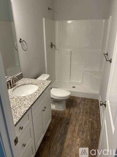 A bathroom with a toilet, sink, and shower.