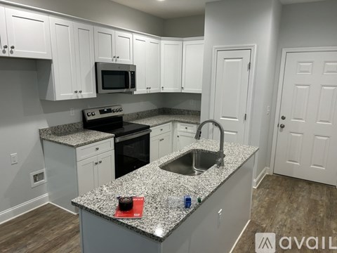 A kitchen with granite countertops and white cabinets.