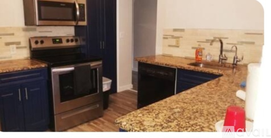 A kitchen with a granite countertop and dark blue cabinets.
