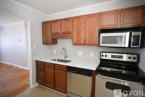 A kitchen with wooden cabinets and a black stove top oven.