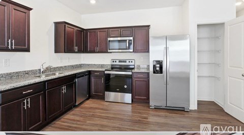 A kitchen with dark wood cabinets and stainless steel appliances.