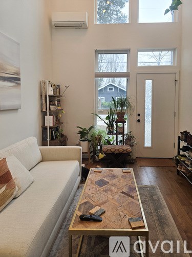 A living room with a white couch and a wooden coffee table.