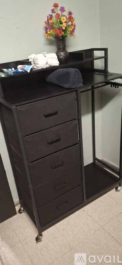 A black dresser with a vase of flowers on top.