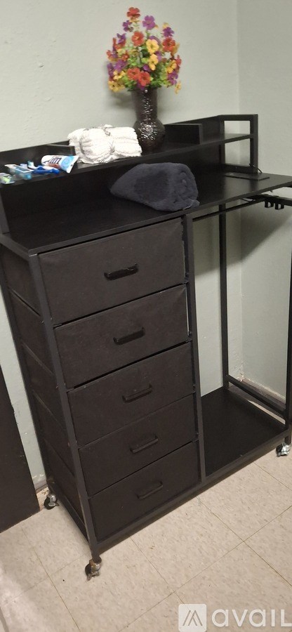 A black dresser with a vase of flowers on top.