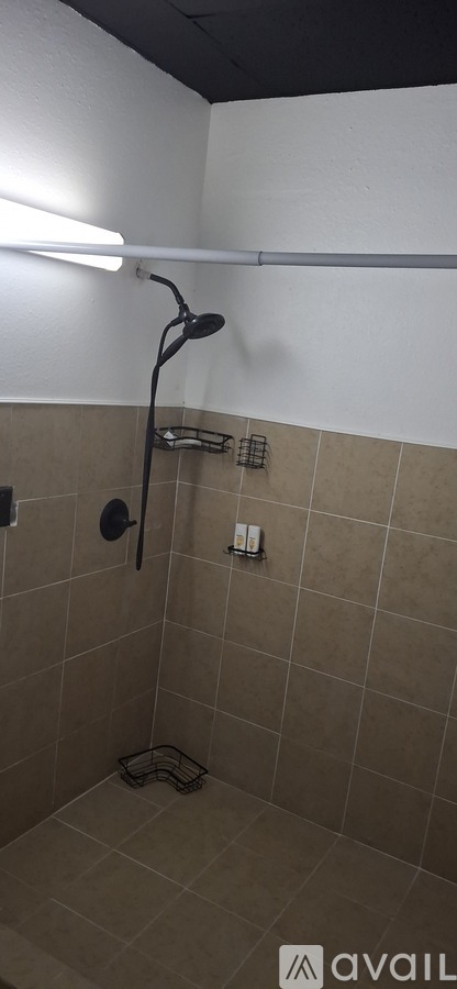 A bathroom with beige tiles and a white wall.