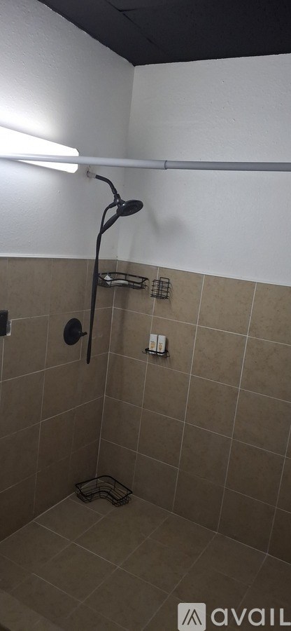 A bathroom with beige tiles and a white wall.