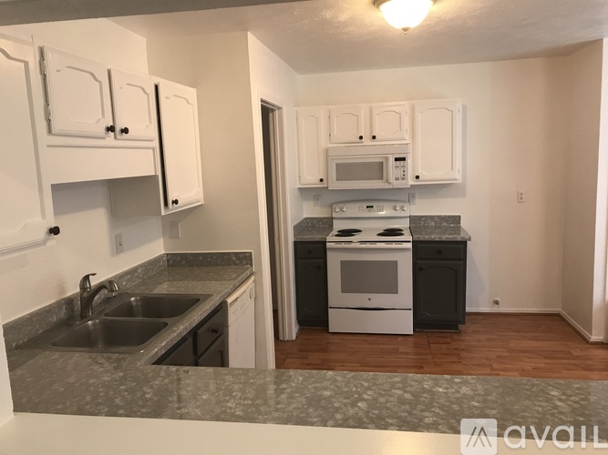 A kitchen with white cabinets and a sink.