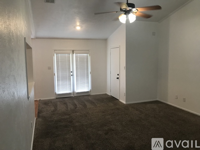 A room with a ceiling fan and carpeted floor.
