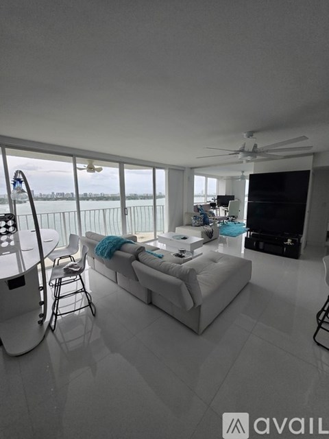 A modern living room with a large window overlooking the water.