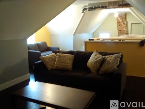 A living room with a black couch and a coffee table.