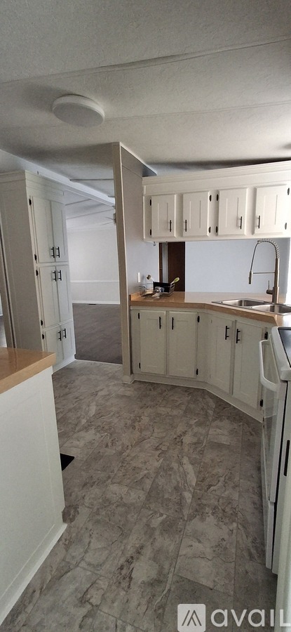 A kitchen with white cabinets and a tiled floor.