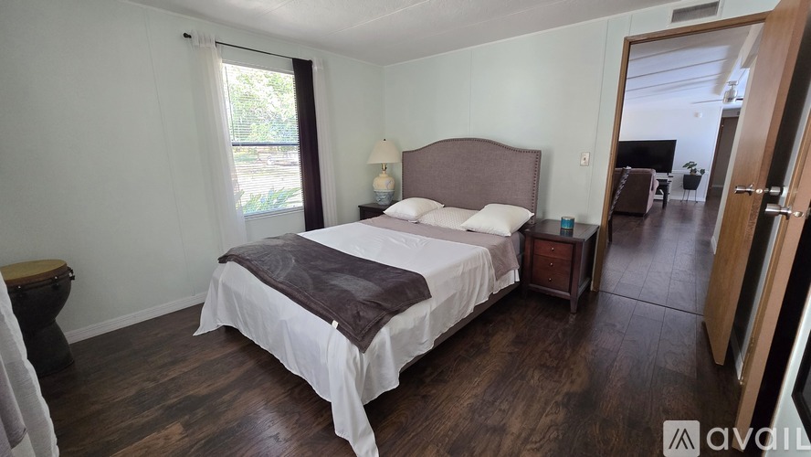A bedroom with a large bed and a window.