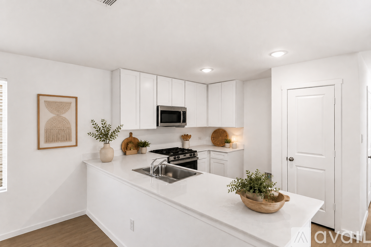 A kitchen with white cabinets and a white countertop.