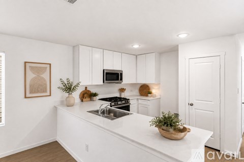 A kitchen with white cabinets and a white countertop.