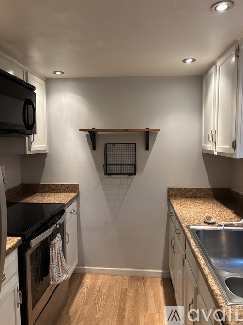 A kitchen with a black microwave, stove, and oven.
