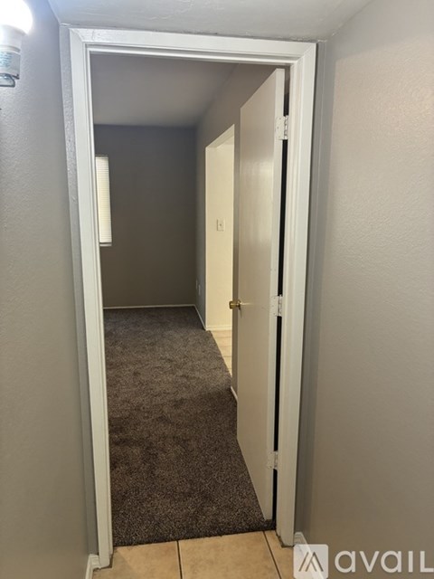 A hallway with a carpeted floor and a door on the right.