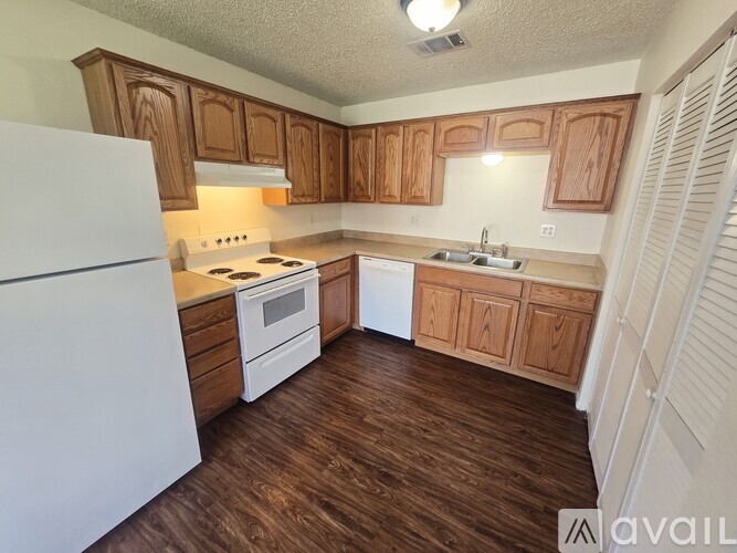 A kitchen with wooden cabinets and white appliances.