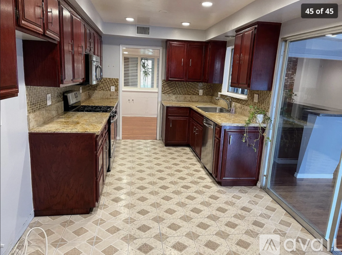 A kitchen with brown cabinets and a checkered floor.