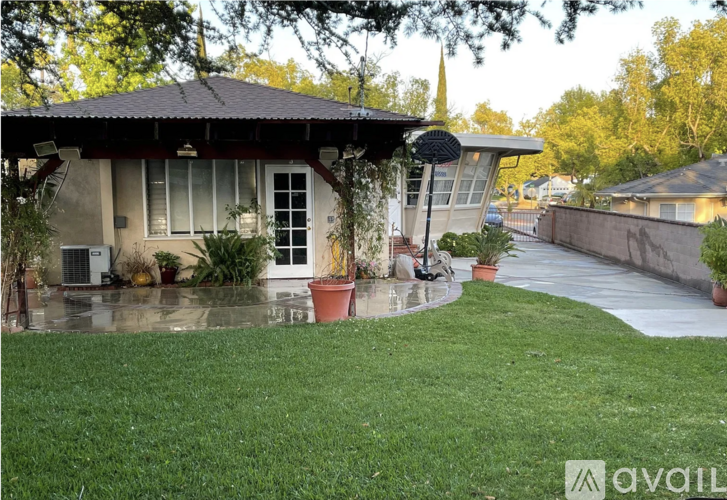 A house with a patio and a tree in front of it.