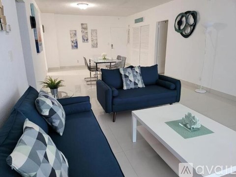 A living room with a dark blue couch and a white coffee table.