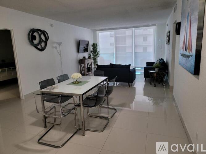 A dining room with a white table and chairs.