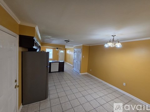 A living room with a television and a refrigerator.
