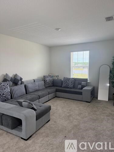 A living room with a grey sofa and a grey armchair.