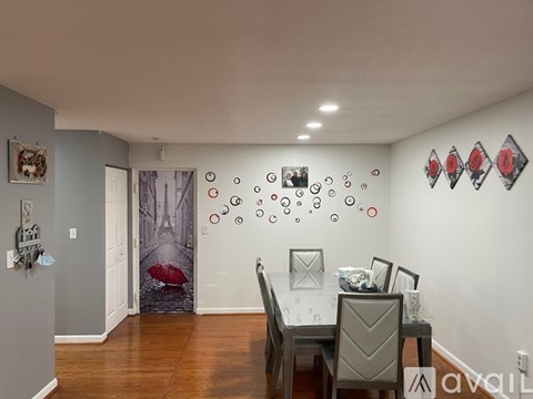 A dining room with a table set for two and a wall mural of a red umbrella.