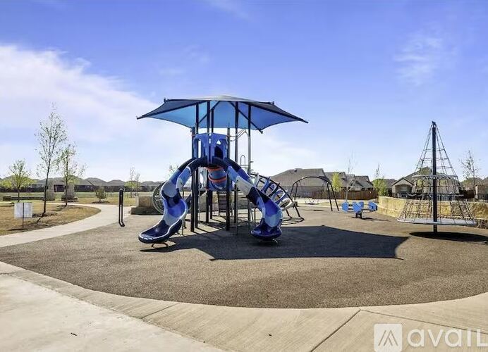 A playground with a blue umbrella and slide.