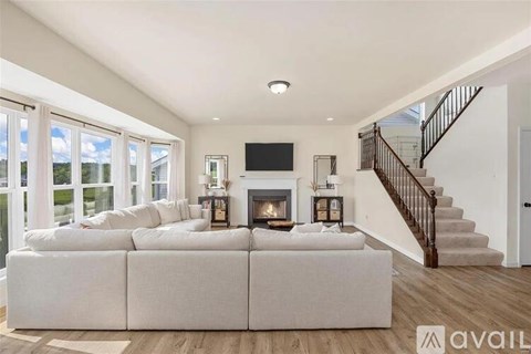 A living room with a white couch and a fireplace.