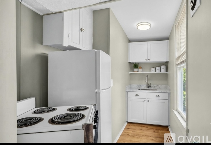 A kitchen with a white stove and cabinets.