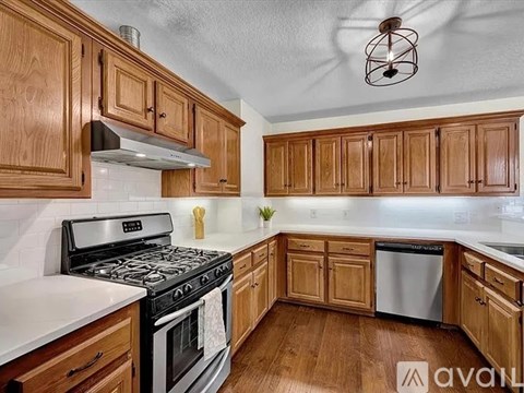 A kitchen with wooden cabinets and a stove top oven.