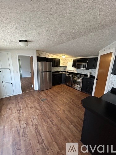 A kitchen with wooden floors and stainless steel appliances.