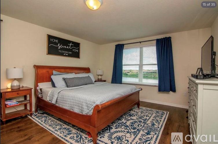 A bedroom with a bed, nightstand, and window.