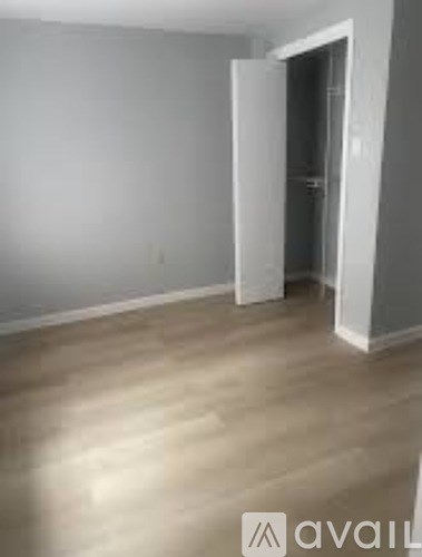 A room with a wooden floor and a white wall.
