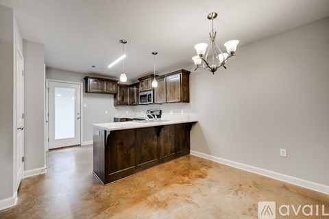 A kitchen with a brown counter top and a chandelier hanging from the ceiling.