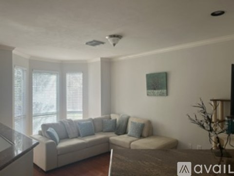 A living room with a couch and a painting on the wall.