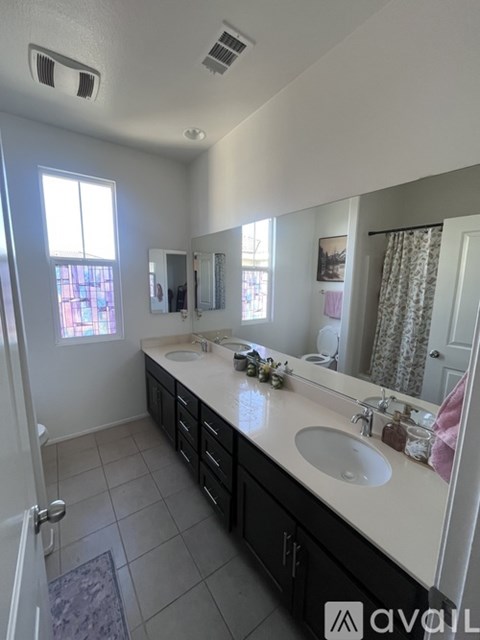 A bathroom with two sinks and a large mirror.