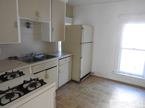 A kitchen with a white stove and a white refrigerator.