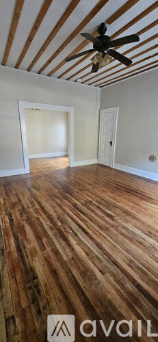 A room with wooden floors and a ceiling fan.