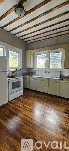 A kitchen with wooden floors and white appliances.