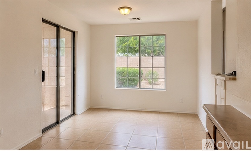 A spacious room with a sliding glass door leading to a balcony.